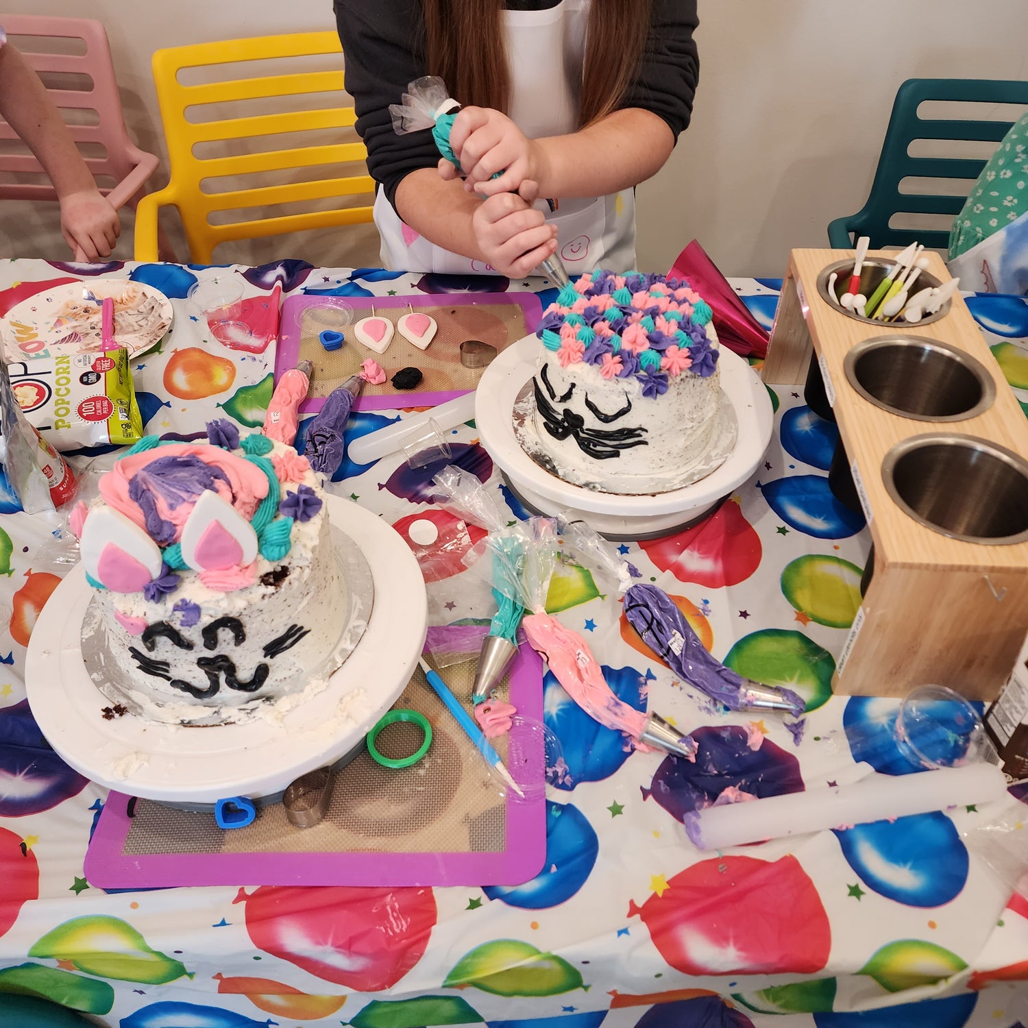 Kids decorate cakes like a cat during a Bob Ross cake-decorating party at Cake Hoopla in the Portland area.