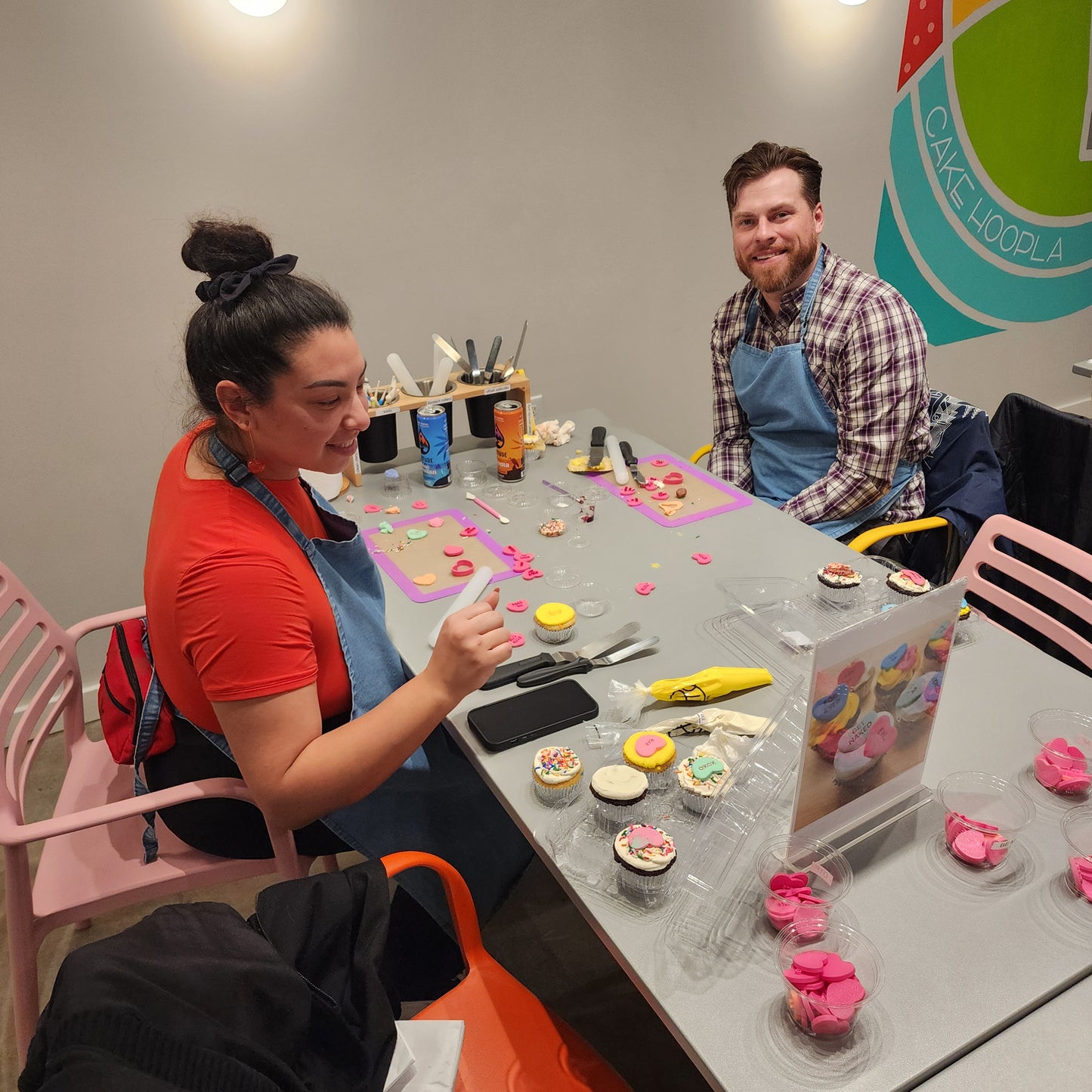 An adult couple enjoying Valentine's Day cupcake-decorating at Cake Hoopla in Tigard, Oregon near Portland.