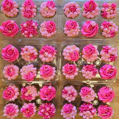 Pink floral-themed cupcakes decorated with light and dark pink rosettes and stars and gold leaf; pre-decorated cupcakes shipped to the continental US.