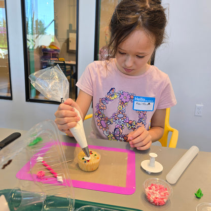 A girl decorates a cupcake during summer cake camp at Cake Hoopla in Tigard, Oregon near Portland.