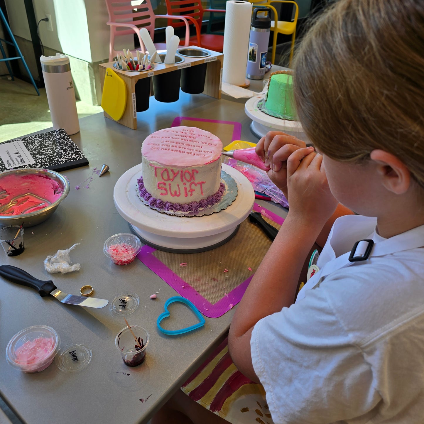 A girl decorates a Taylor Swift themed cake at a Swiftie summer cake camp at Cake Hoopla in Tigard, Oregon near Portland.