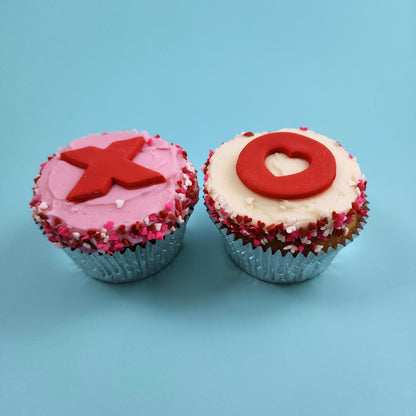 Cupcakes frosted pink and white with red and pink Xs and Os, hearts, and sprinkles from the Hugs, Kisses, Cupcakes DIY cupcake-decorating kit available during open studio time, to-go, or as pre-decorated cupcakes from Cake Hoopla in Tigard, Oregon near Portland.