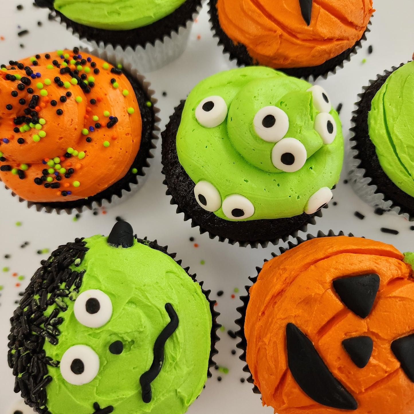 Halloween-themed cupcakes decorated like monsters, pumpkins, and jack o'lanterns available by shipping from Cake Hoopla.