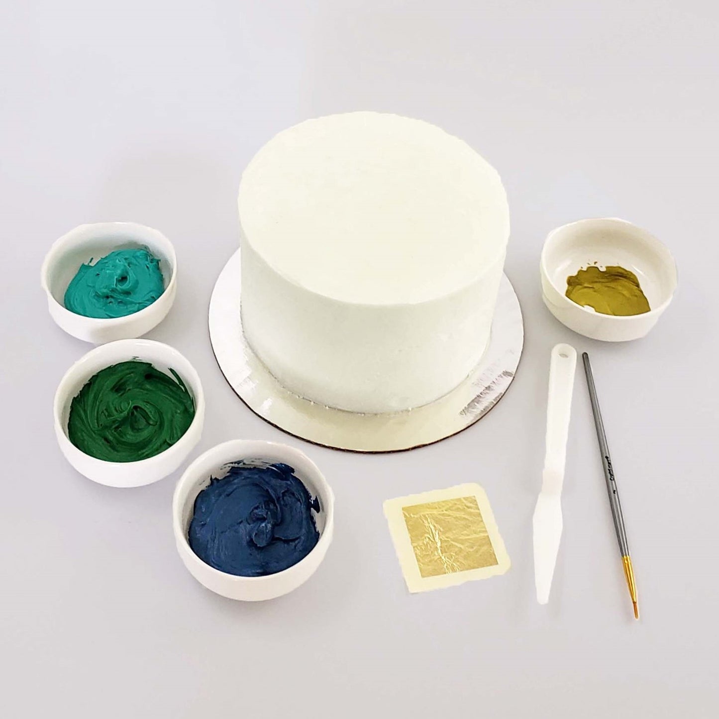 Picture of the Classy as Fine Gold cake kit before decorating, including frosting, gold accents, and tools, available during open studio time at Cake Hoopla in Tigard, Oregon.