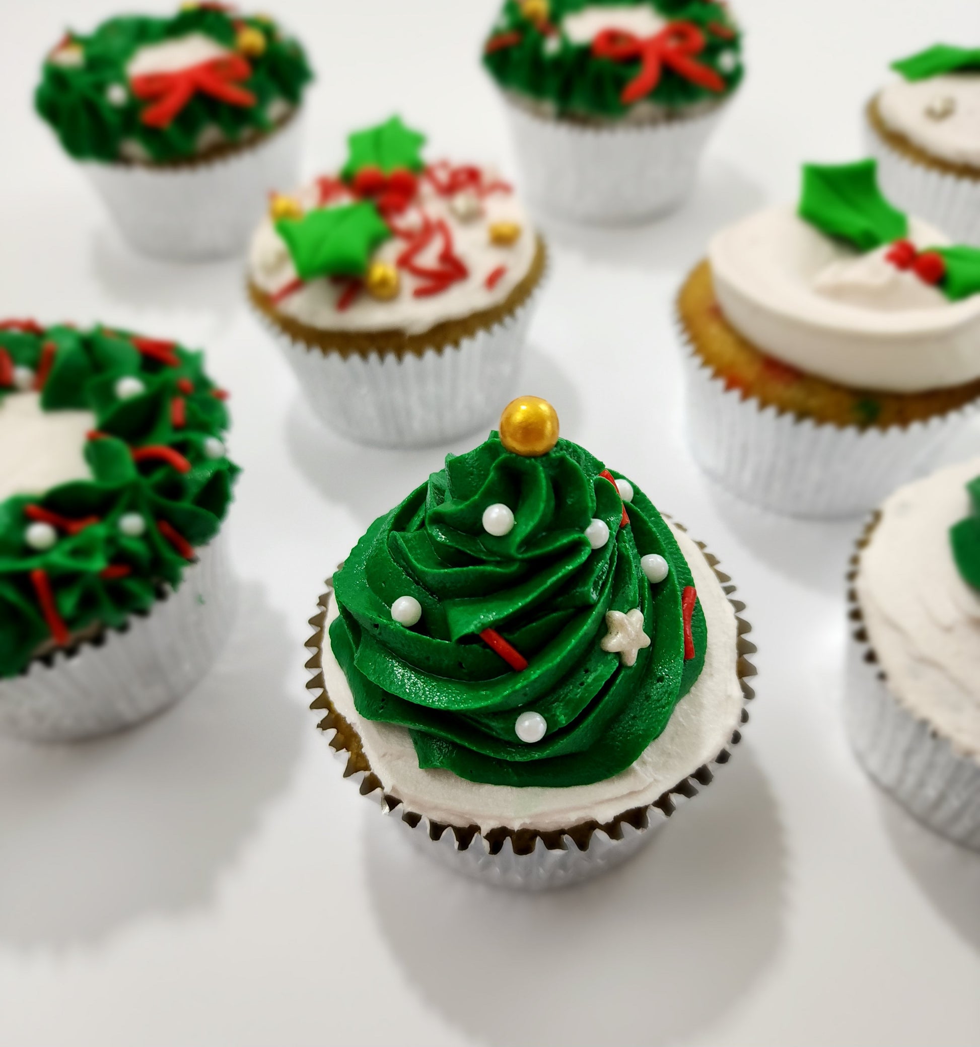 DIY cupcake decorating Christmas cupcake. Green frosting tree with sprinkles as ornaments on top of the cupcake.